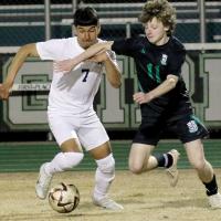 Angel Martinez tries to push past McGuinness player for control of the ball