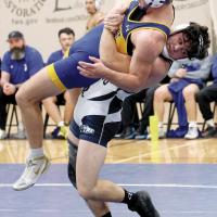 Theron Davis looks toward the mat as he leans back into a takedown throw of Piedmont’s Ian Mitchell
