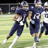 Kaleb Blackwolf runs behind the block of Hunter Davidson