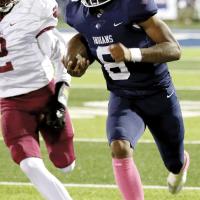Elijah Fisher runs away from a tackler after picking up the football