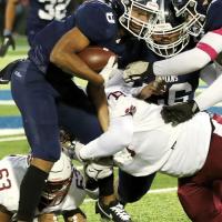 JaRon Irving attempts to shake off a leg tackle by an Ardmore player