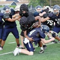 A group of El Reno tacklers converge on a ball carrier for a loss