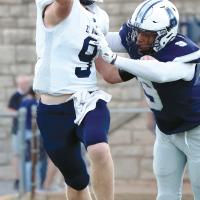 Rustyn Cook gets hit in the upper chest just as he releases a pass