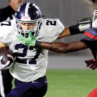 Tucker McDaniel tries to stiff-arm his way through a face mask