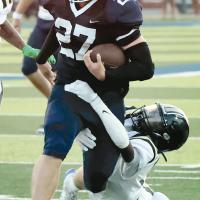 Grant First (27) drags a Midwest City tackler for extra yards