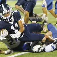 Bentley Evans leans over two Noble tacklers to gain extra yards