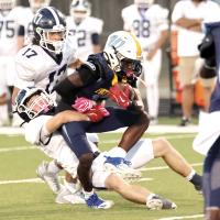 Cooper Cobble pulls down a Putnam City West ball carrier as Jaydon Steele closes in to help