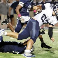 Grant First (27) runs through a tackle attempt by a Shawnee defender