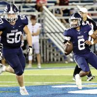  Elijah Fisher rolls out for a pass attempt behind the protection of Cade Houston