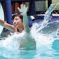 Isaac Leslie raises his hands as he slides out of a tube
