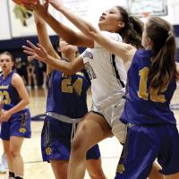Pauline Black-Harmon shoots a one-handed layup under two defenders