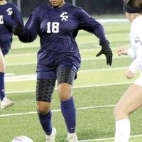 Maddie Rochdi dribbles the ball by a Woodward defender