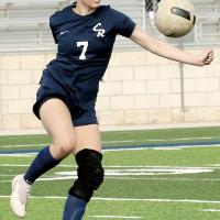 Reece Hardy twists her upper body as she sets up to kick a bouncing ball 