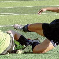 Lily Menjivar grimaces as she hits her ankle on the shin of the OKC Storm goalie