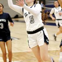 Raegan Bugaj slides between defenders to shoot a fastbreak layup