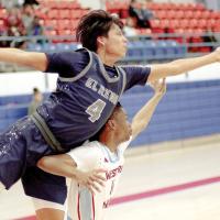 Josiah Reveles jumps over the top of a Western Heights player to tip a rebound to a teammate