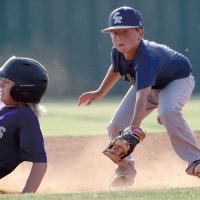 Ashton Ezell looks toward another runner after tagging out a Bethany player