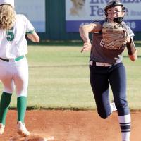 Iliana Ashford sidesteps a base runner as she throws toward first base