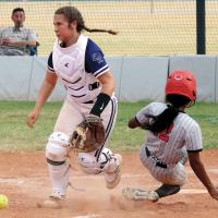 Lily Arnold chases down a deflected ball as a Carl Albert runner slides into home