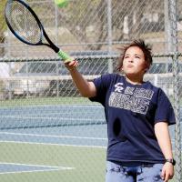 Jayna Graham hits a high forehand return shot