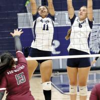 Meredick Martinez (11) and Ruby Curtis (6) set up for a block attempt
