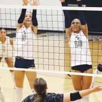 Quinn Charmasson (9) and Mary Gonzalez (16) team up for a double block attempt