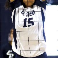 Qyra Jones reaches high over the net to attempt a block