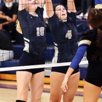 Avery Peffer and Jennis Goucher reach for a double block