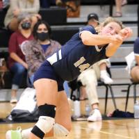 Bailey Denwalt reaches out while running backward to dig up a shot