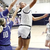 Lilly Thomas twists her body to shoot a reverse layup