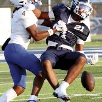 Xzavier Karty (21) tries to grab the football after being hit