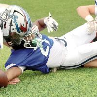 Xzavier Karty (21) falls over while reaching for first down yardage after catching a pass