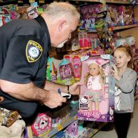 Sam Webster checks for the price of a doll picked out by his shopping buddy Journey Cochran
