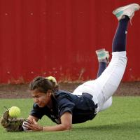 Justine Johnson grimaces as she hits the ground after diving for a fly ball