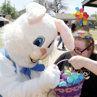 Aldina Watson holds up her basket of eggs for inspection by the bunny