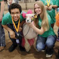 Riley Montgomery poses for a photo with a sheep and Regan Azevedo