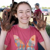Emma Selensky shows her hands after testing soil during last year’s event