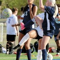 Lily Hayes kicks in a goal in front of teammate Ja’Niya Loreto (23)