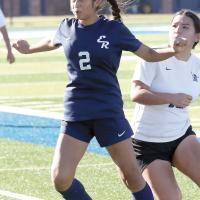 Sinthia Puebla uses her upper body to control a pass from a teammate