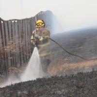 A firefighter from FCI El Reno sprays a mixture of water and foam