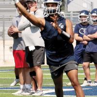 Elijah Fisher throws a pass on a roll-out play