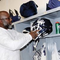 Fred Slaughter places a new helmet in a player’s locker