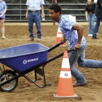 Jake Vulgamore guides a wheelbarrow around a cone
