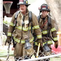 Sgt. Slade Terry and firefighter Gage Pittman carry equipment from the fire