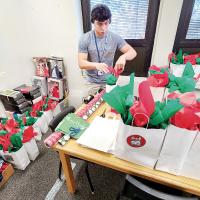 Hunter Davidson ties one of the gift bags for the Gifts for the Yanks program