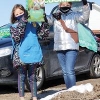 Makayla and Chloe Owen hold up signs to attract passing motorists
