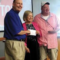 Matt Goucher, left, and Matt White present Donna Dyer with a check