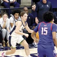 Rodney Haydon (standing) watches a play
