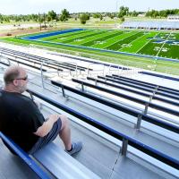 Rodney Haydon, left, and Chuck Atchison look over the new turf at Memorial Stadium