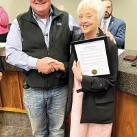 Steve Jensen presents Carolyn Husmann with a plaque honoring her for her dedication to victims of domestic abuse